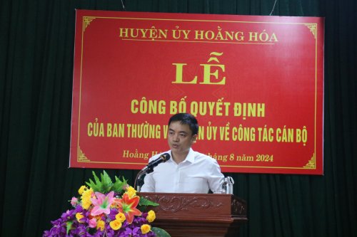 A person standing at a podium

Description automatically generated