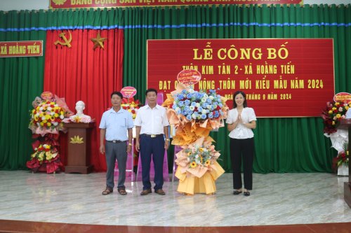 A group of people standing in front of a stage

Description automatically generated